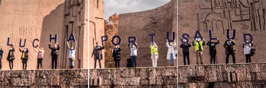 Un grupo de personas forman un mensaje levantando letras: "Lucha por tu salud"